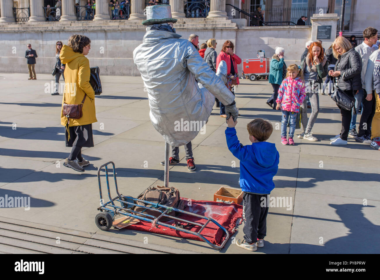 Mann gemalt als Silver menschliche Statue auf dem Trafalgar Square, London, England, UK. Stockfoto