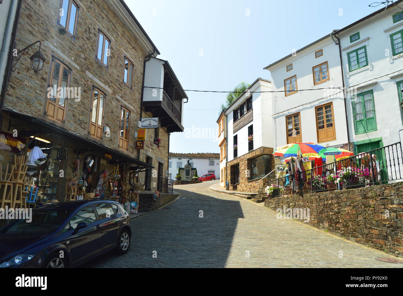 Straßen mit Schiefer Gebäude mit Geschäften im Erdgeschoss zu einem schönen Platz in Taramundi, Asturien, Spanien führt. Architektur, Geschichte, Reisen Stockfoto