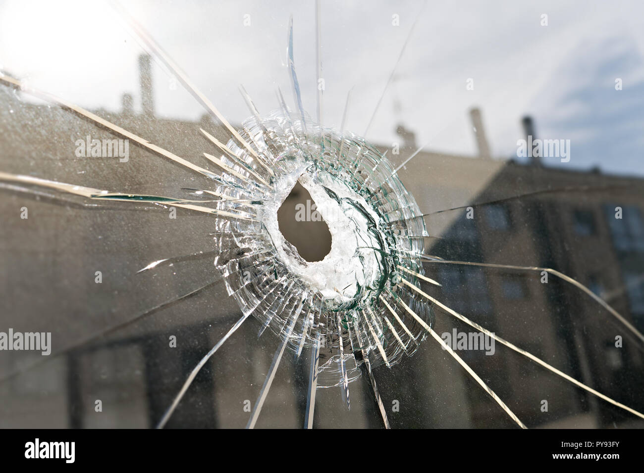 Vandalismus oder Gewalt Konzept. Zerbrochenes Glas mit Bohrung Stockfoto