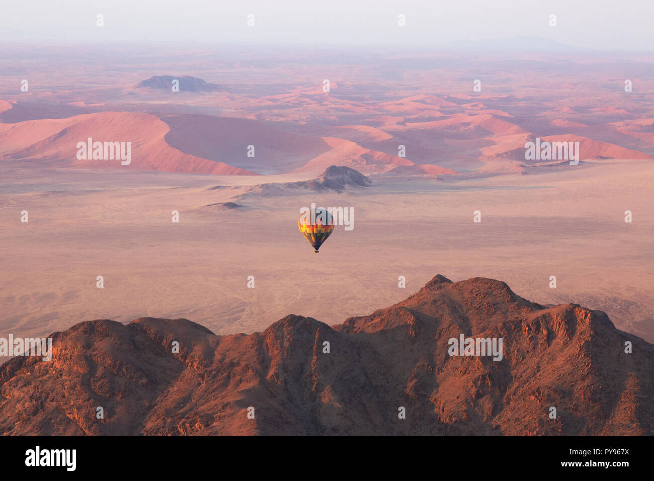 Namibia Travel - Heißluftballon bei Sonnenaufgang über den Sanddünen der Namib-Wüste - Beispiel für Adventure Travel, Namibia Afrika Stockfoto