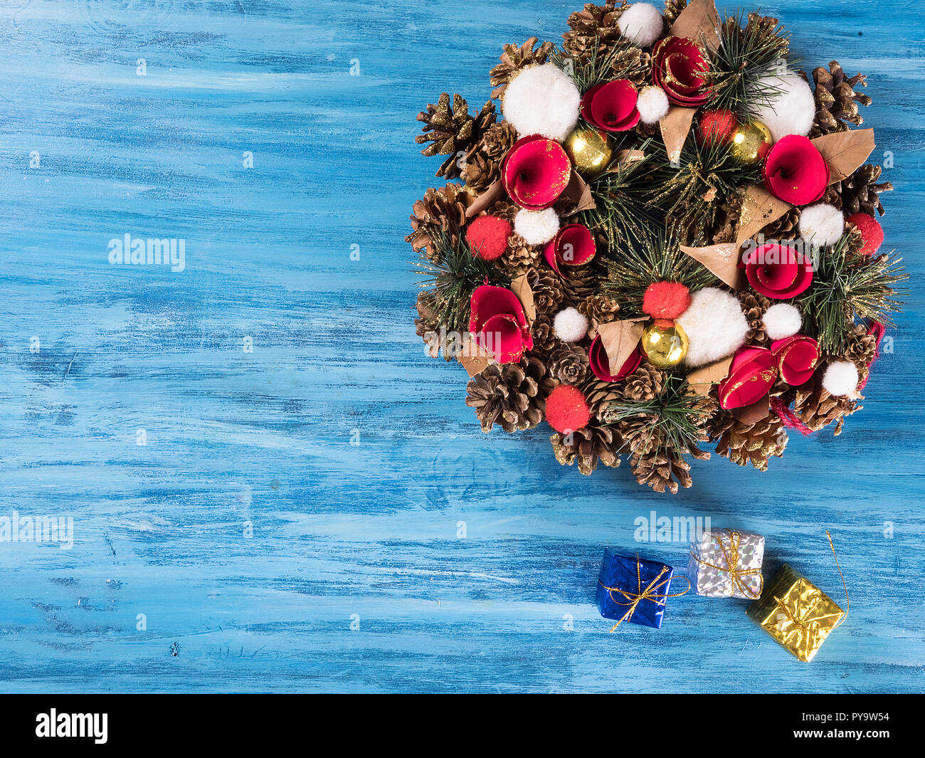 Chistmas Tür Dekoration mit kleinen Geschenkboxen auf Blau Holz- Hintergrund. Gruß Symbol. Stockfoto