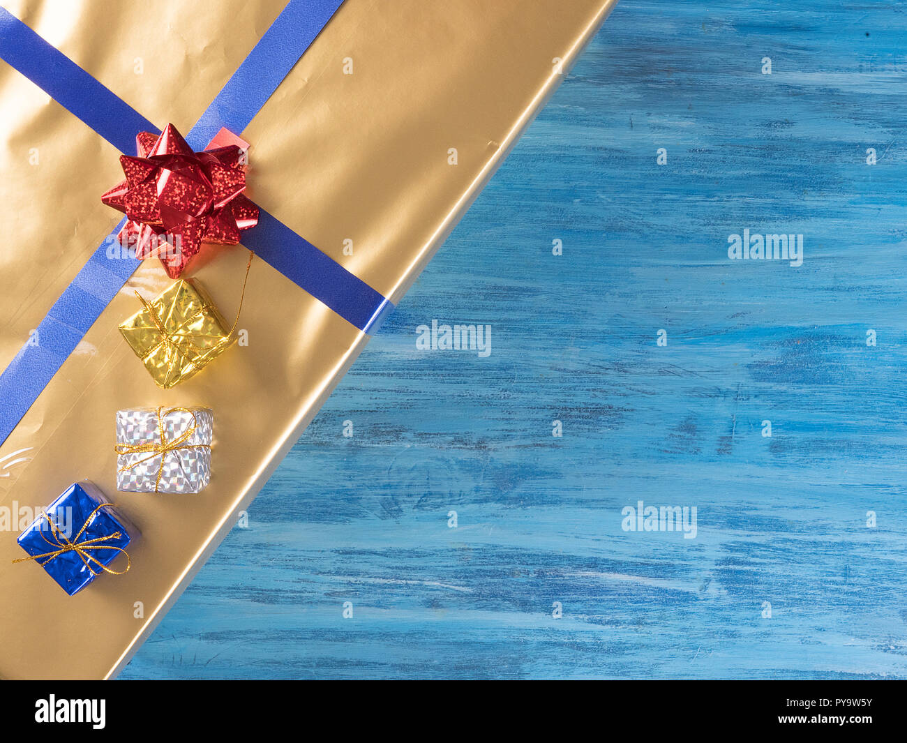 Blick von oben auf die goldene Weihnachten Geschenkboxen auf alten Vintage blau Holz- Hintergrund. Winter Feier Stockfoto