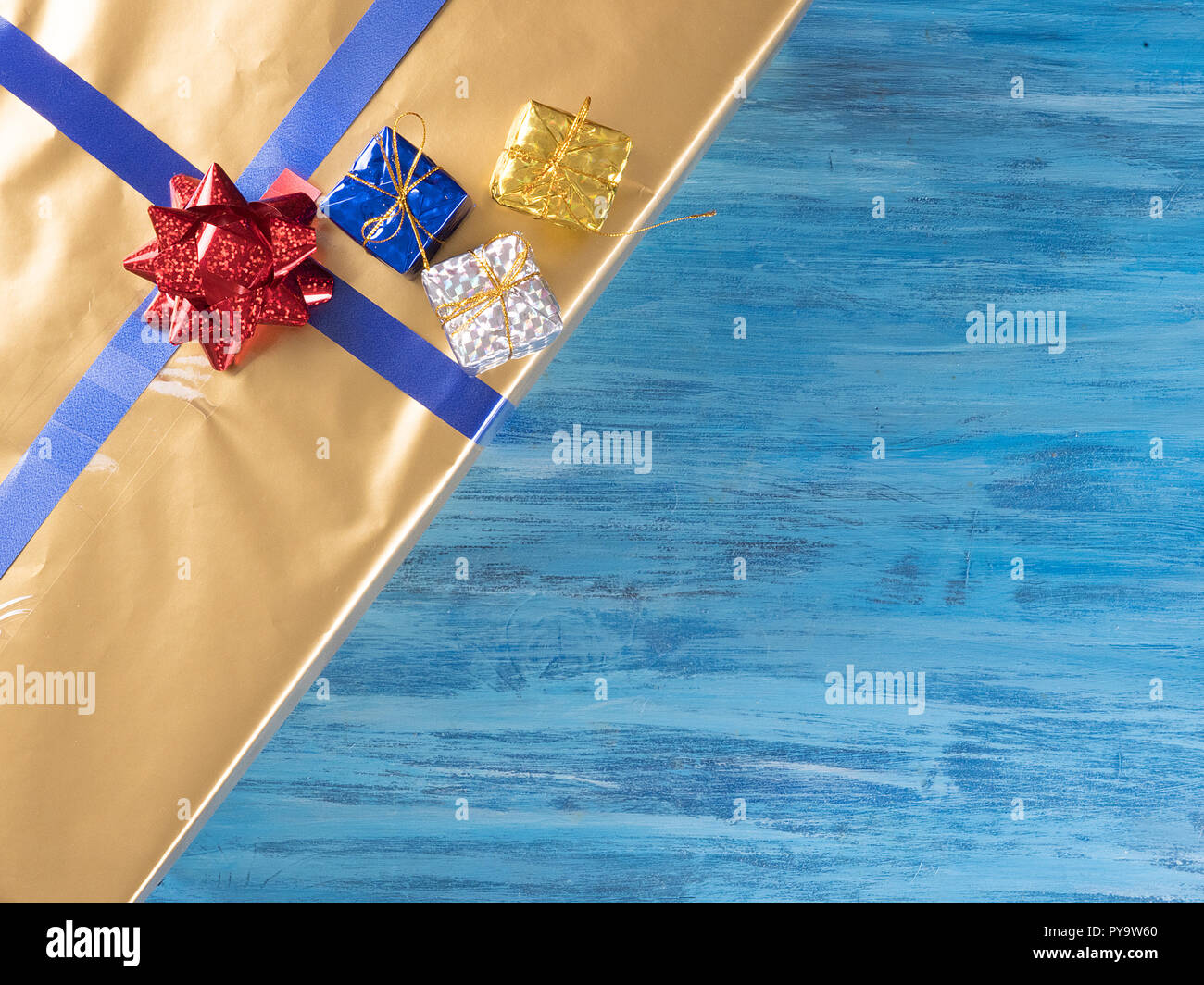 Blick von oben auf die goldene Weihnachten Geschenkboxen auf alten Vintage blau Holz- Hintergrund. Winter Feier Stockfoto