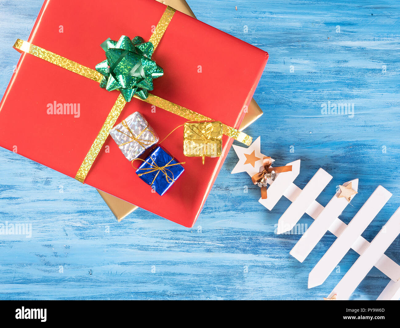 Big Red Christmas gift Box mit kleineren Boxen auf Blue vintage Holz- Hintergrund. Feier Symbol. Stockfoto