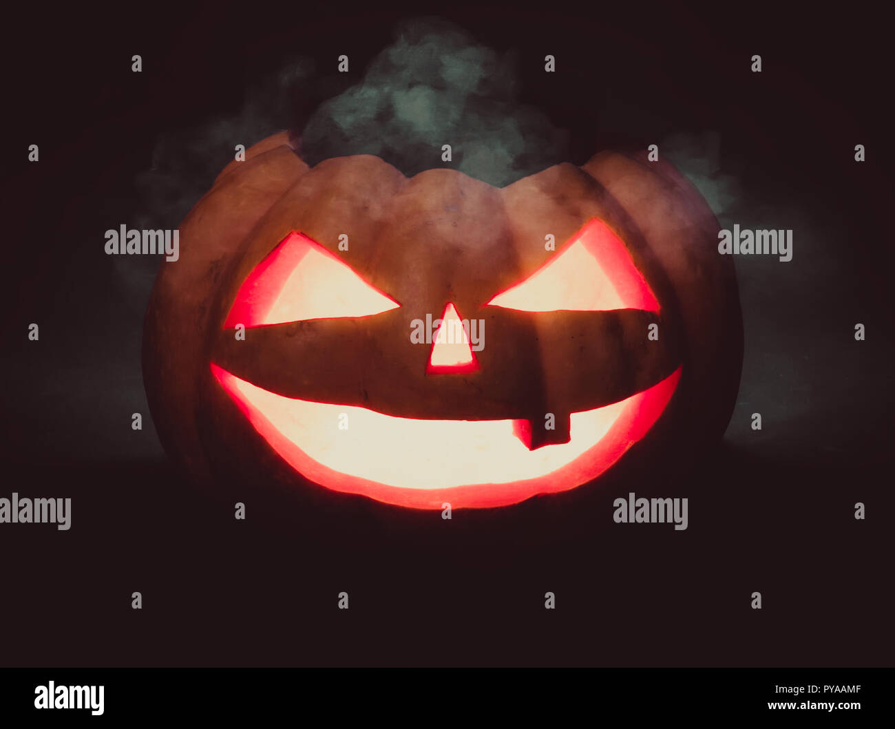 Halloween Kürbis scary face Jack o Lanternon auf dunklem Hintergrund Stockfoto