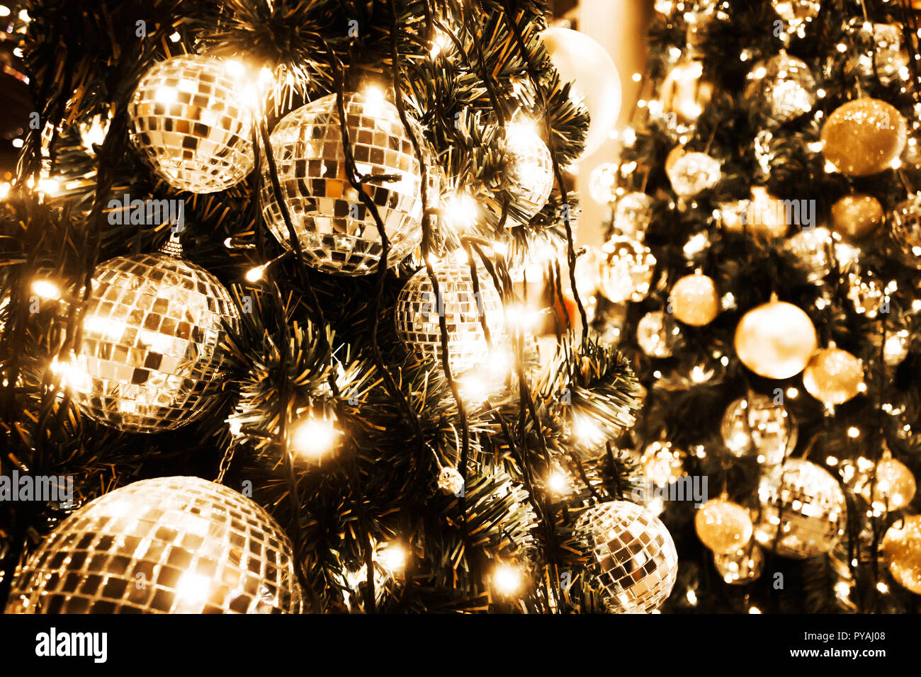 Weihnachtsbaum mit gold Kugel und bokeh Lichter Hintergrund. Xmas abstrakte Close up mit leuchtenden Dekorationen im Freien. Stockfoto