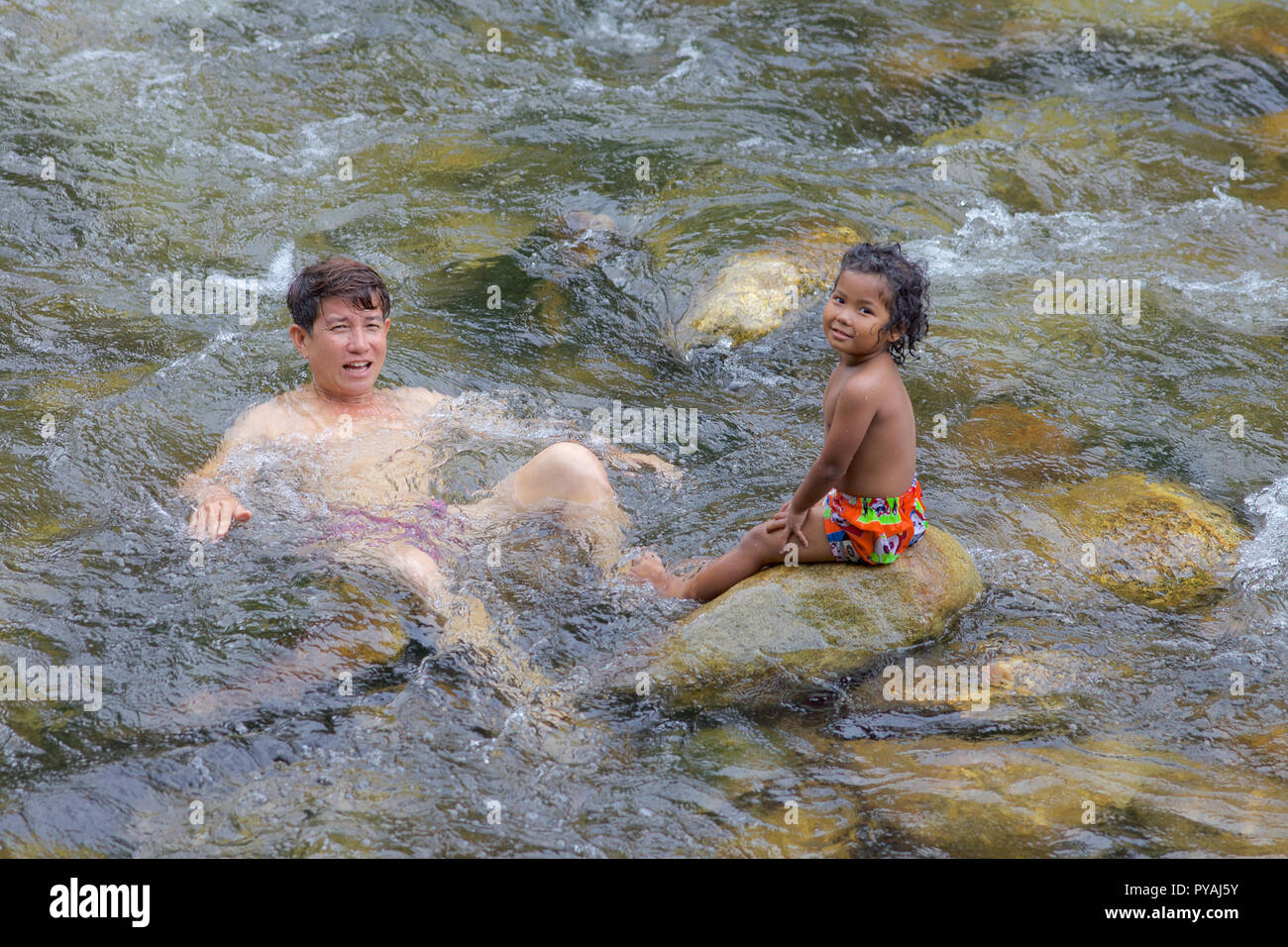Eine junge Thai Girl und Papa in einem Fluss in Nakhon si Thammarat, Thailand. Stockfoto