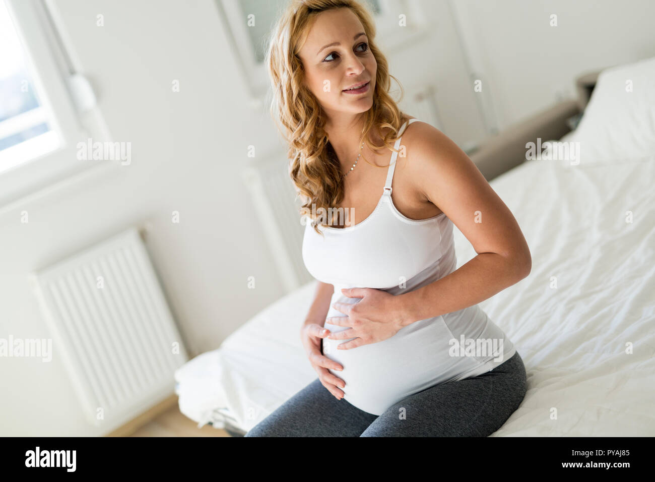 Portrait von Stolz schwangere Frau im Schlafzimmer Stockfoto