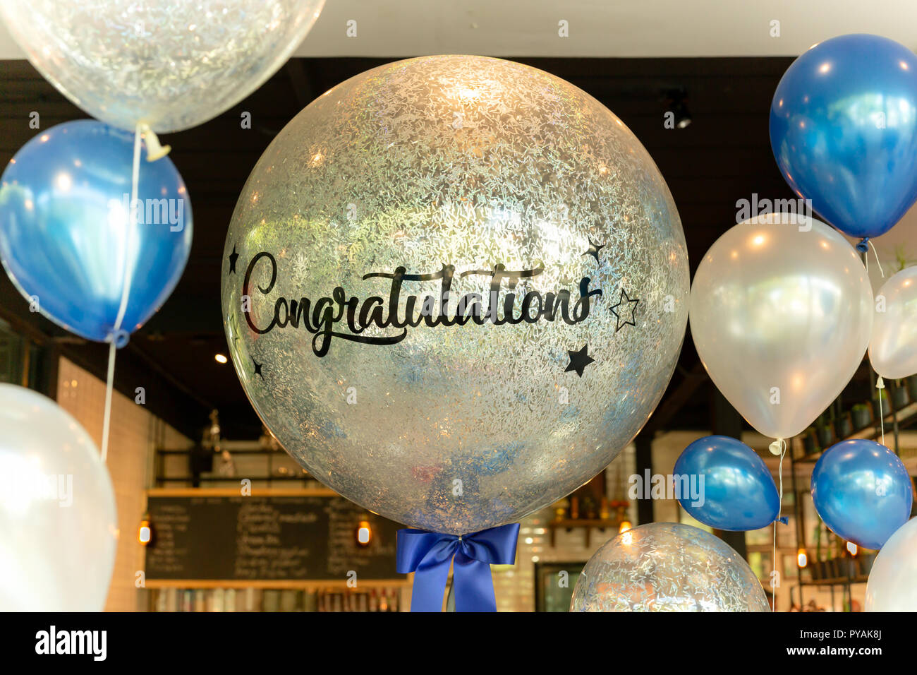 Luftballons mit Wort herzlichen Glückwunsch zu Ballon Dekoration im Restaurant. Stockfoto