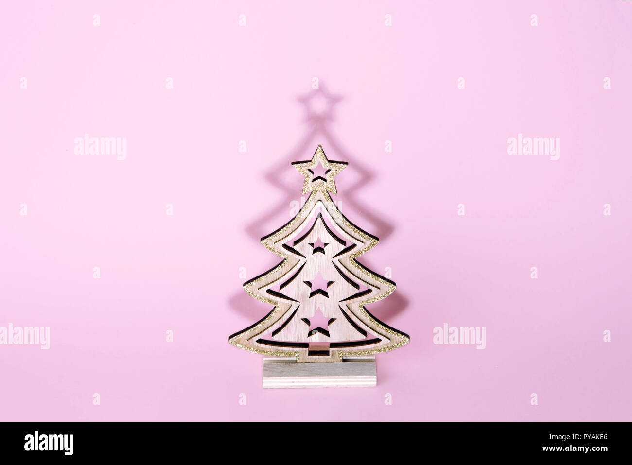 Weihnachten Holz- Baum über leicht rosa unterlegt. Weihnachten und Urlaub Konzept. Stockfoto