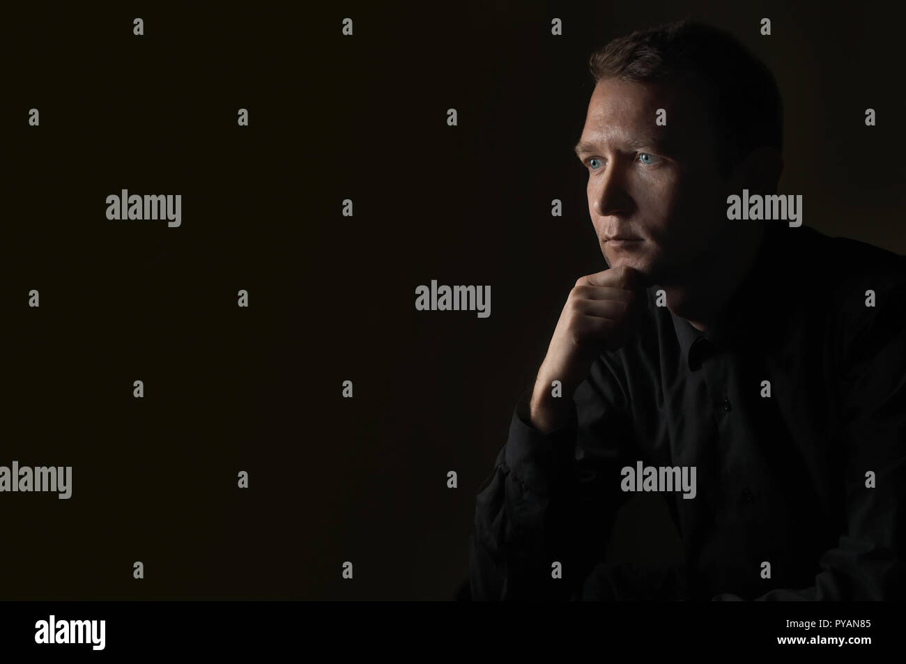 Junger Mann, Nahaufnahme, Porträt, auf schwarzem Hintergrund auf der Seite Stockfoto