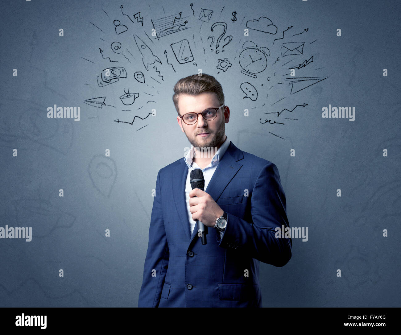 Geschäftsmann sprechen in das Mikrofon mit gemischten Doodles über seinem Kopf Stockfoto