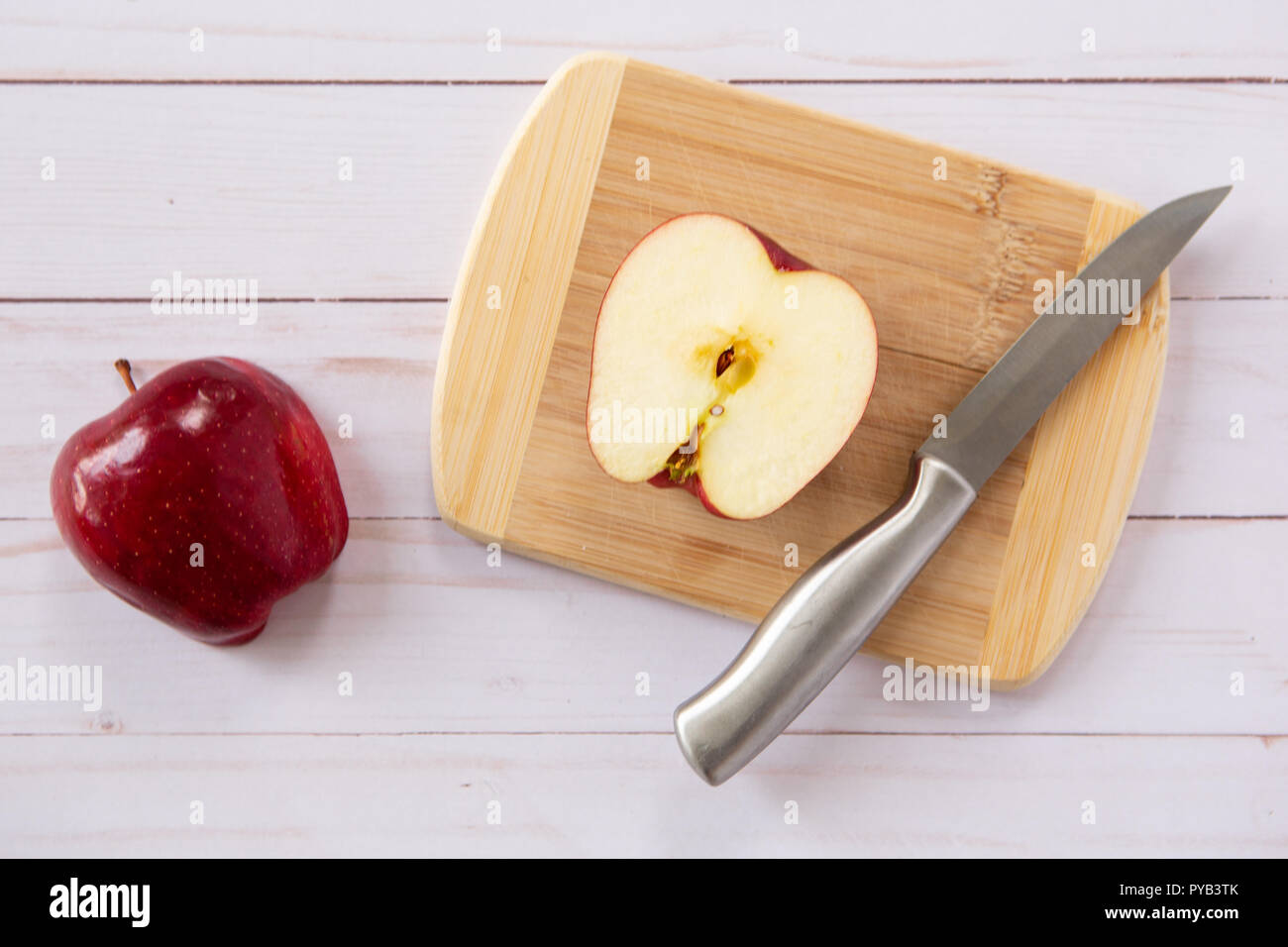 Cut Red Delicious Apple auf Holz Schneidebrett mit Messer Stockfoto