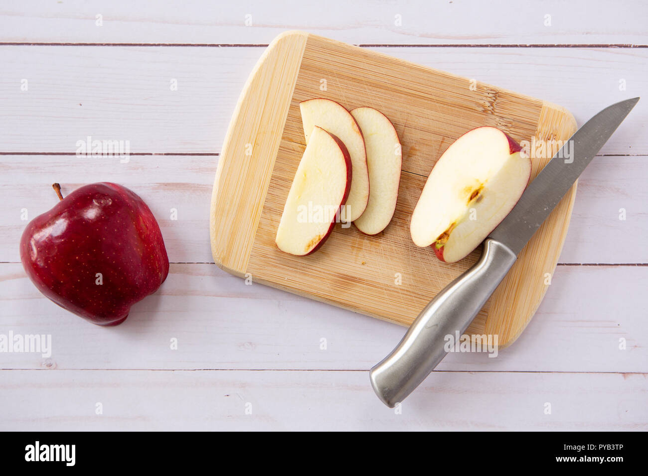 Cut Red Delicious Apple auf Holz Schneidebrett mit Messer Stockfoto