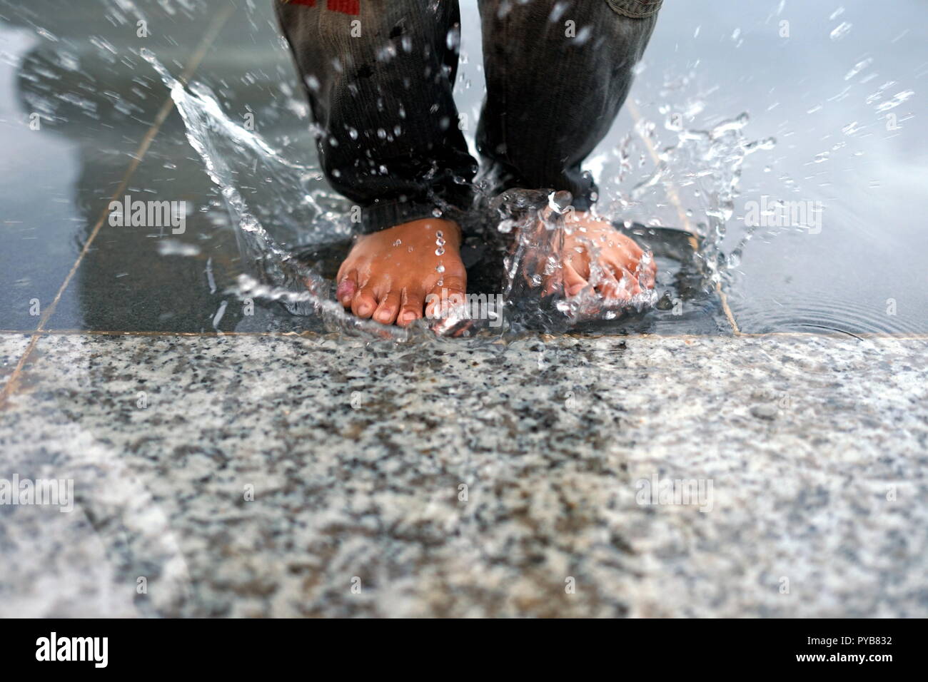 Wasser Spaß. kids Spritzwasser mit Barfuß Stockfoto