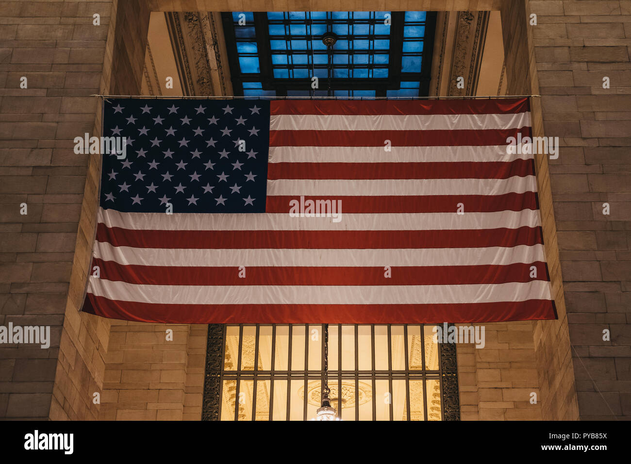 New York, USA - 28. Mai 2018: Große amerikanische Flagge im Grand Central Terminal, dem weltbekannten Wahrzeichen und Verkehrsknotenpunkt in Midtown Manhattan, Stockfoto