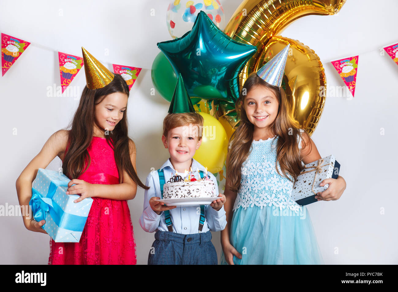 Gruppe Kinder feiern Geburtstag zusammen. Kinder auf der Suche nach Geburtstag Kuchen mit Kerzen Stockfoto
