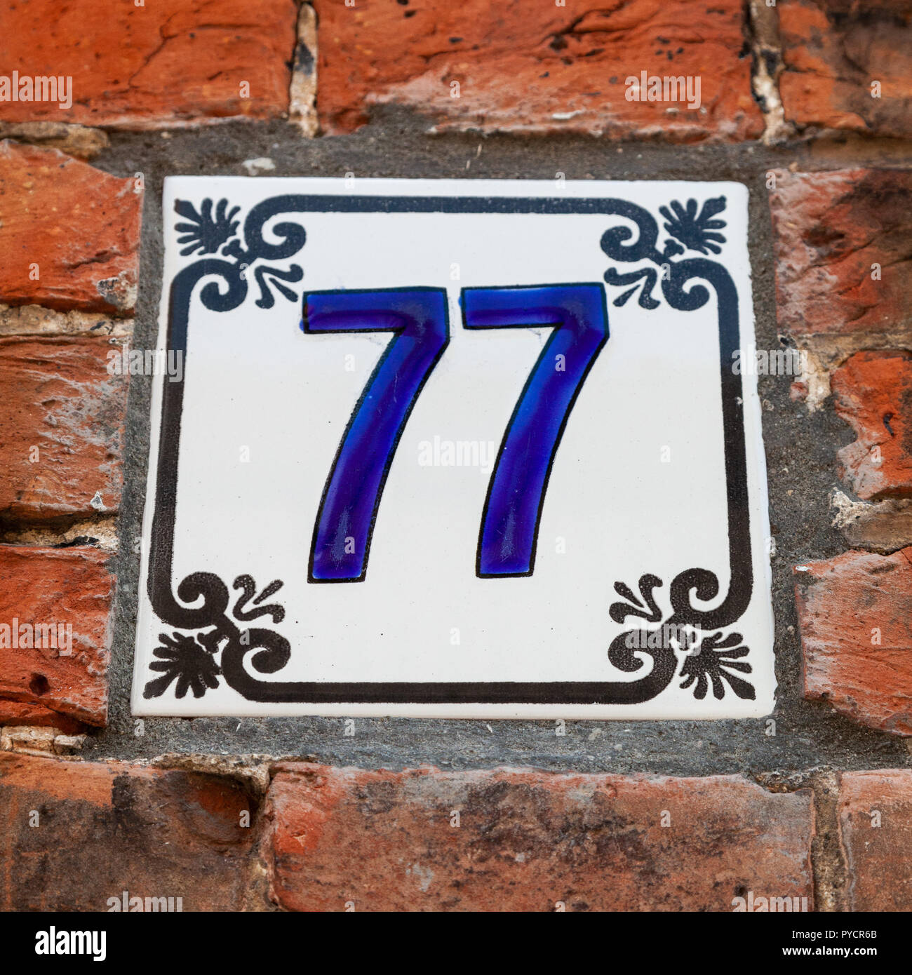 Haus Nummer 77 77 malte auf der keramischen Fliese in Blau und Schwarz mit fleur-de-lis Muster aus Schweden oder Belgien Stockfoto