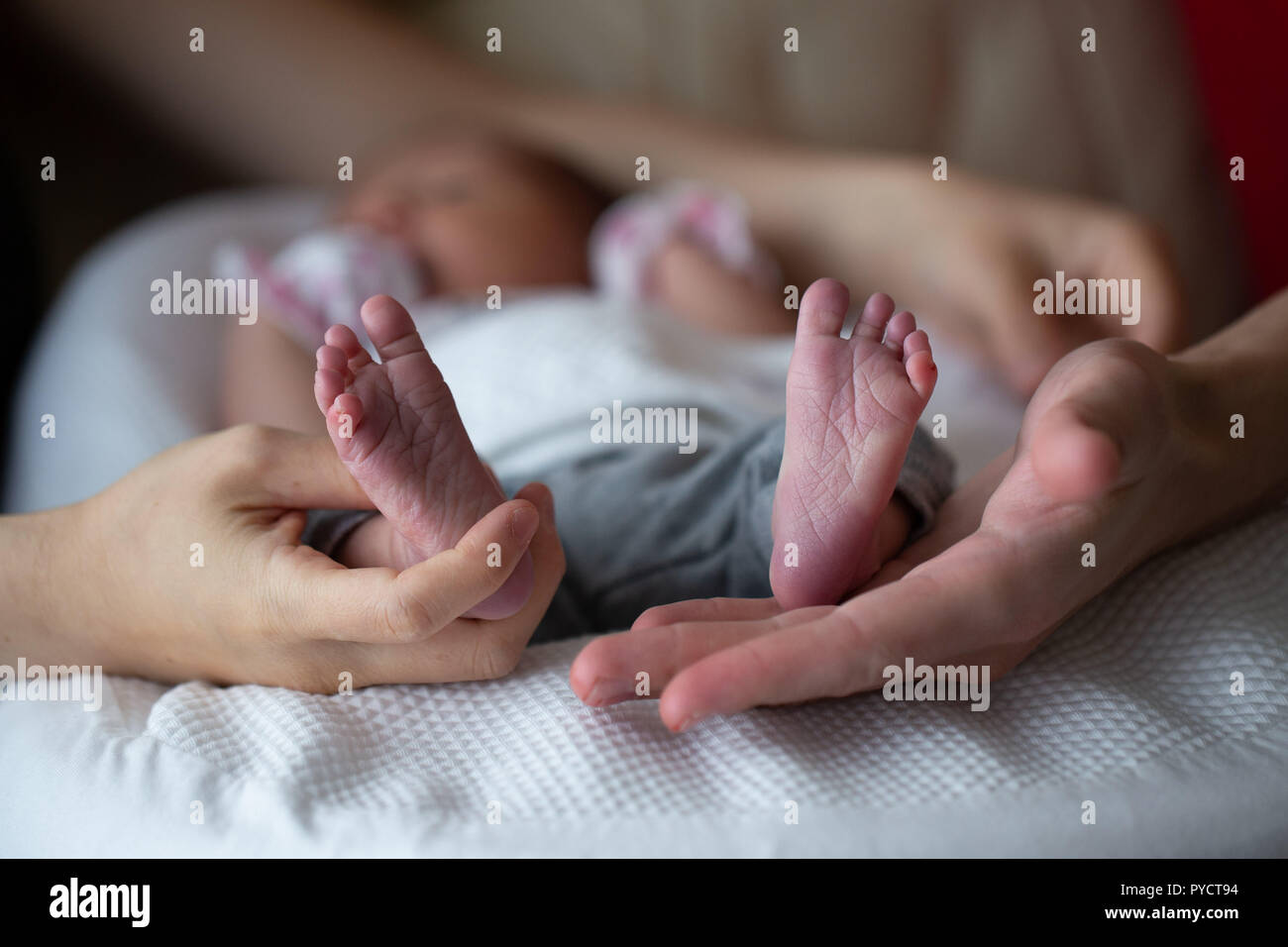 Junges Paar Holding neugeborene Kind Füße mit Palmen, konzeptionelle Bild. Stockfoto