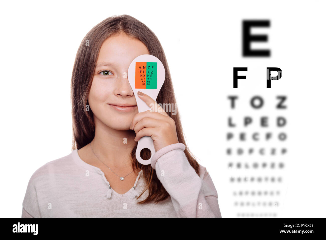 Jugendmädchen in Auge Prüfung mit einem Auge, mit dem Spezialwerkzeug. Auge Test mit Auge Diagramm auf Hintergrund Stockfoto