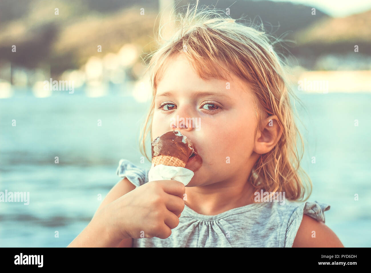 Kleines Mädchen Eis essen am Strand Stockfoto