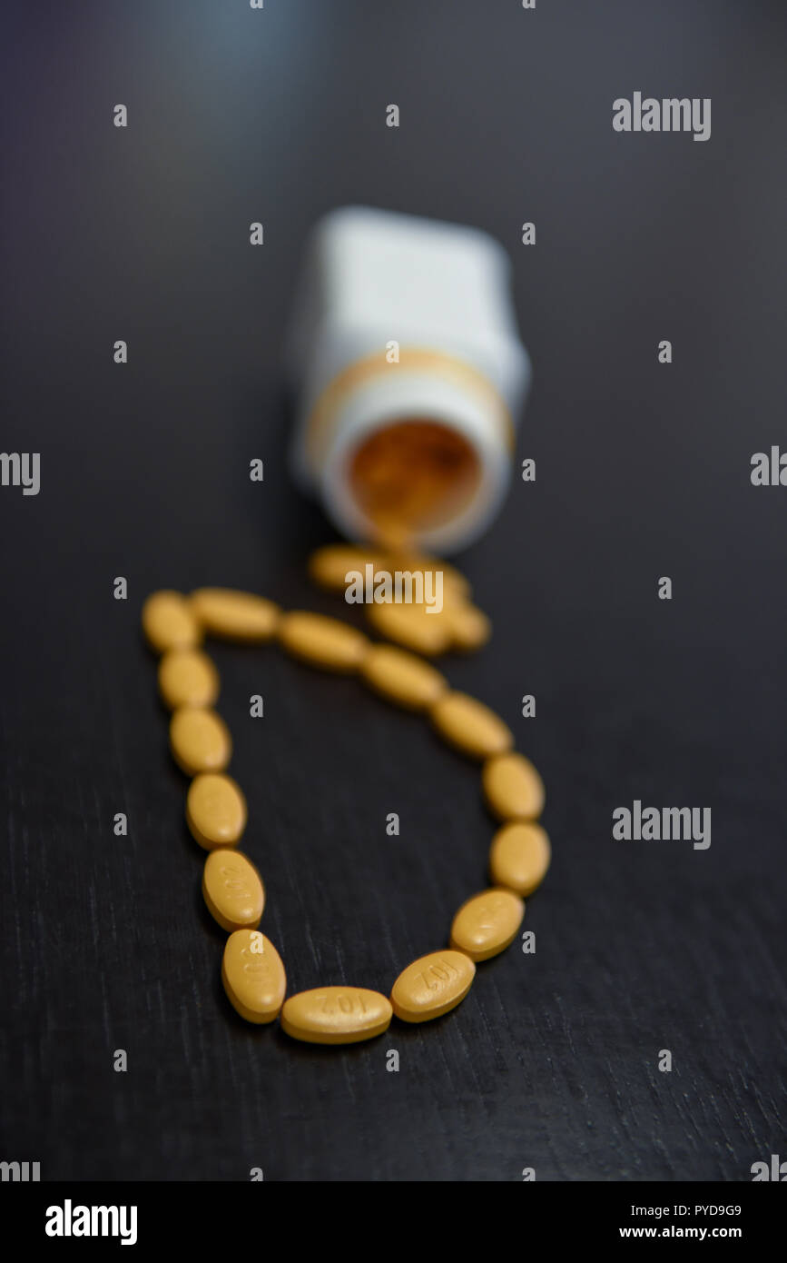 Blick von oben auf die Buchstaben D mit gelben pharmazeutischen Pillen Stockfoto