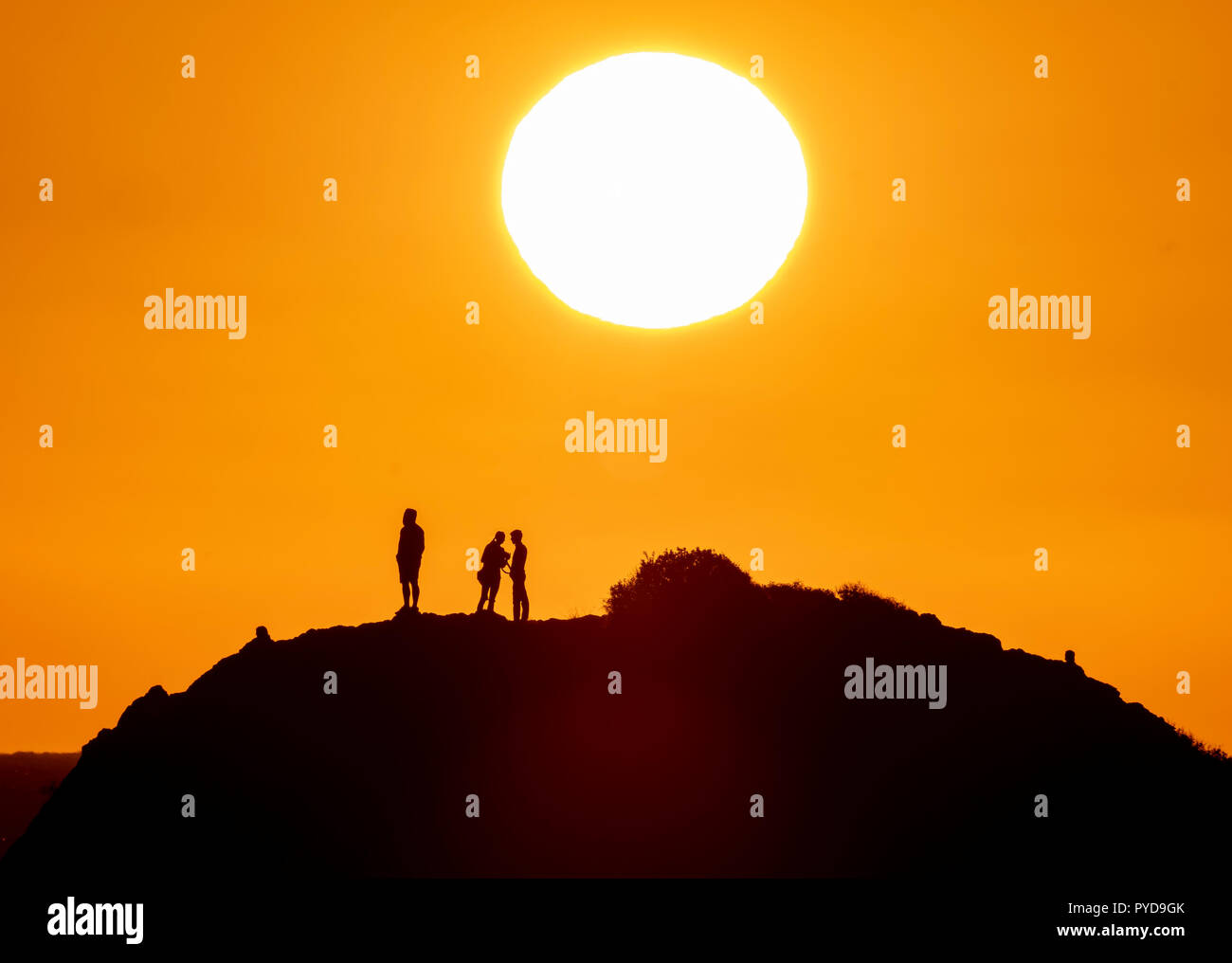 26/10/18: Zypern: Touristen Aussicht auf den Sonnenuntergang von der Spitze von Petra tou Romiou (Rock' des 'Roman') auch als Felsen der Aphrodite bekannt, in der Nähe von Paphos Stockfoto