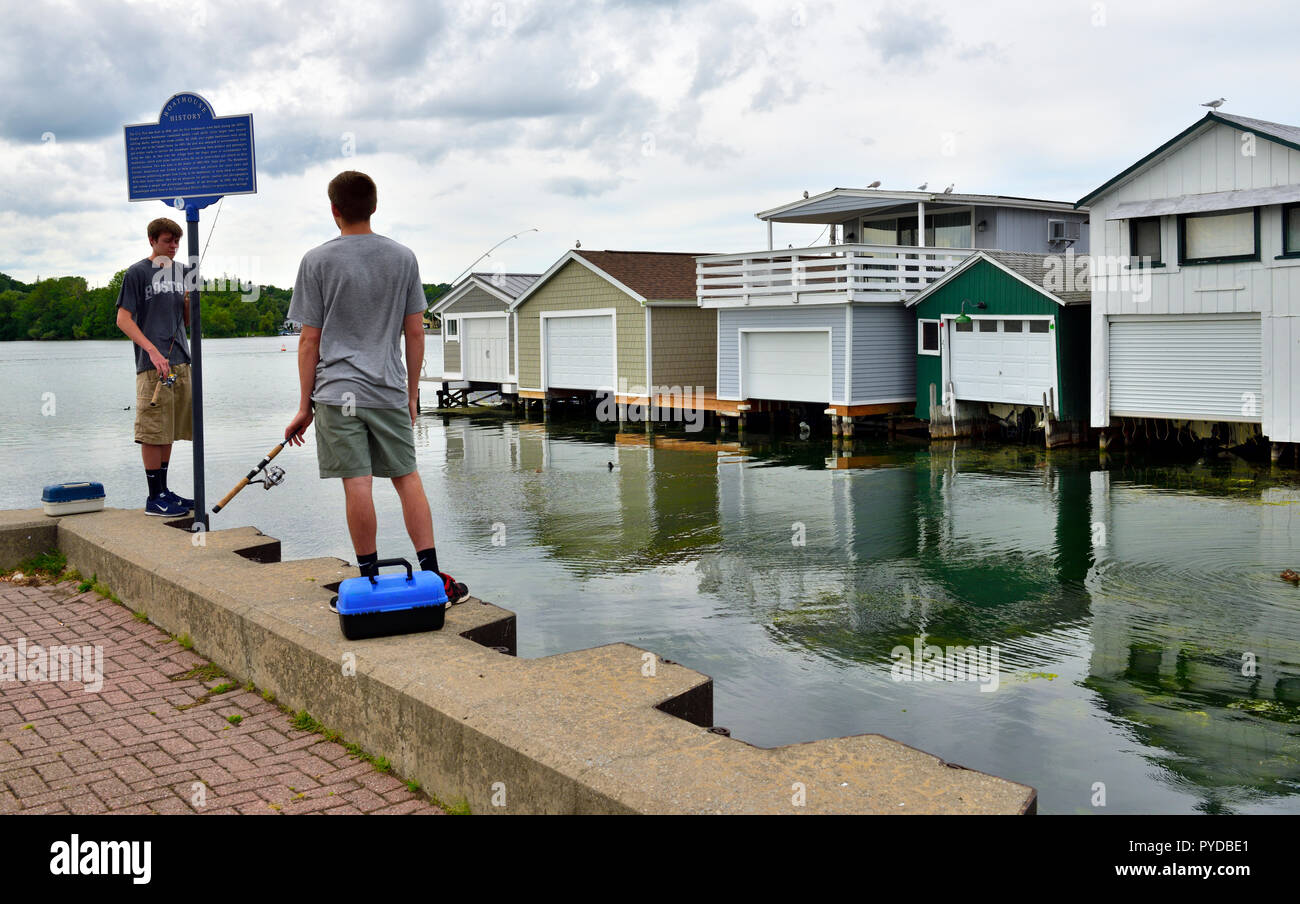 Zwei junge Männer Angeln mit dem Boot Häuser entlang City Pier, Canandaigua See, einem der Finger Lakes, NY, USA Stockfoto