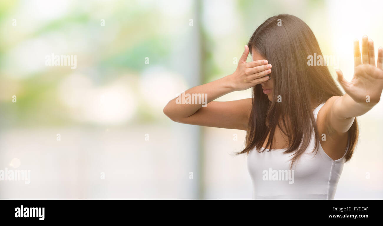 Junge schöne Hispanic mit Sonnenbrille, die Augen mit der Hand und dem Tun stoppen Geste mit traurigen und Angst Ausdruck. Peinlich und negative con Stockfoto