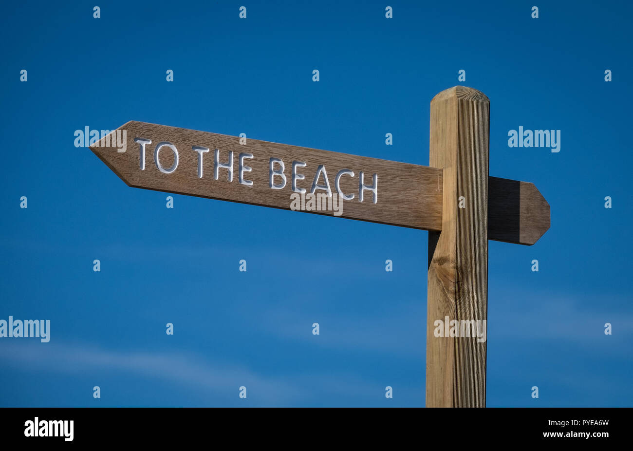 Zum Strand Schild an einem sonnigen Tag vor blauem Himmel Stockfoto
