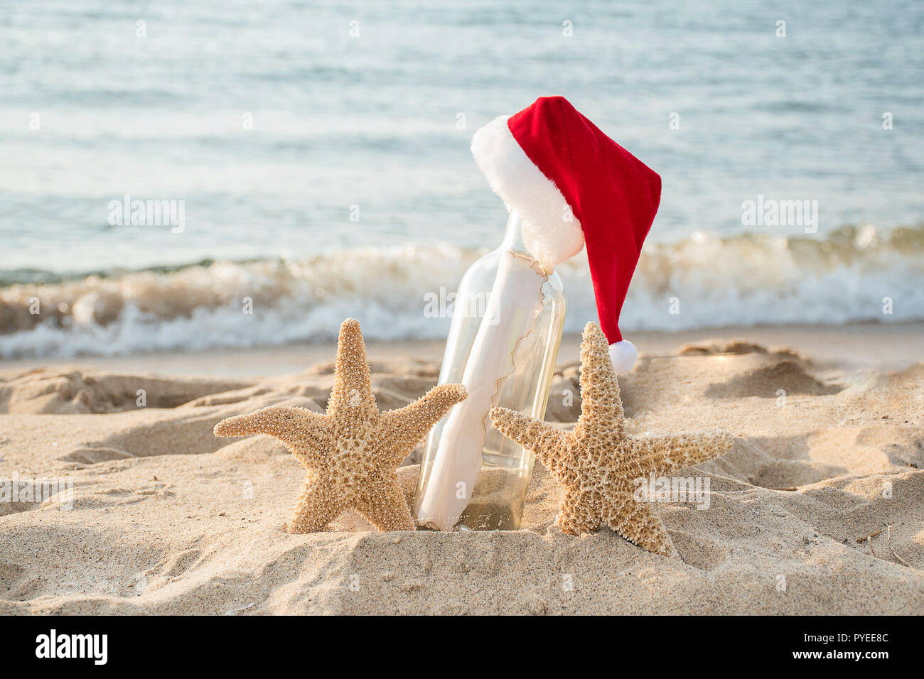 Paar Seesterne mit Santa Hut auf Nachricht in einer Flasche in Strand sand Stockfoto