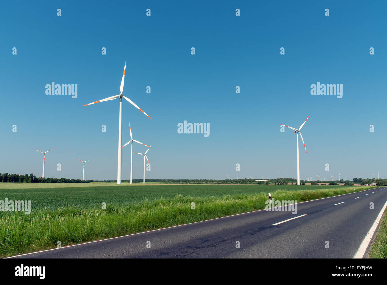 Windenergieanlagen und einer Landstraße in Deutschland gesehen Stockfoto