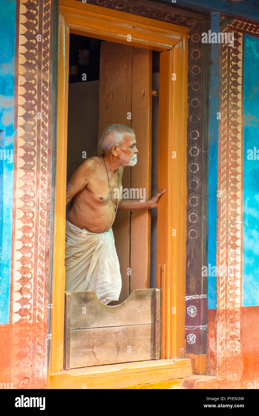 Ältere Inder in einem Dhoti in einem dekorativen Tür, Gokarna, Karnataka, Indien Stockfoto