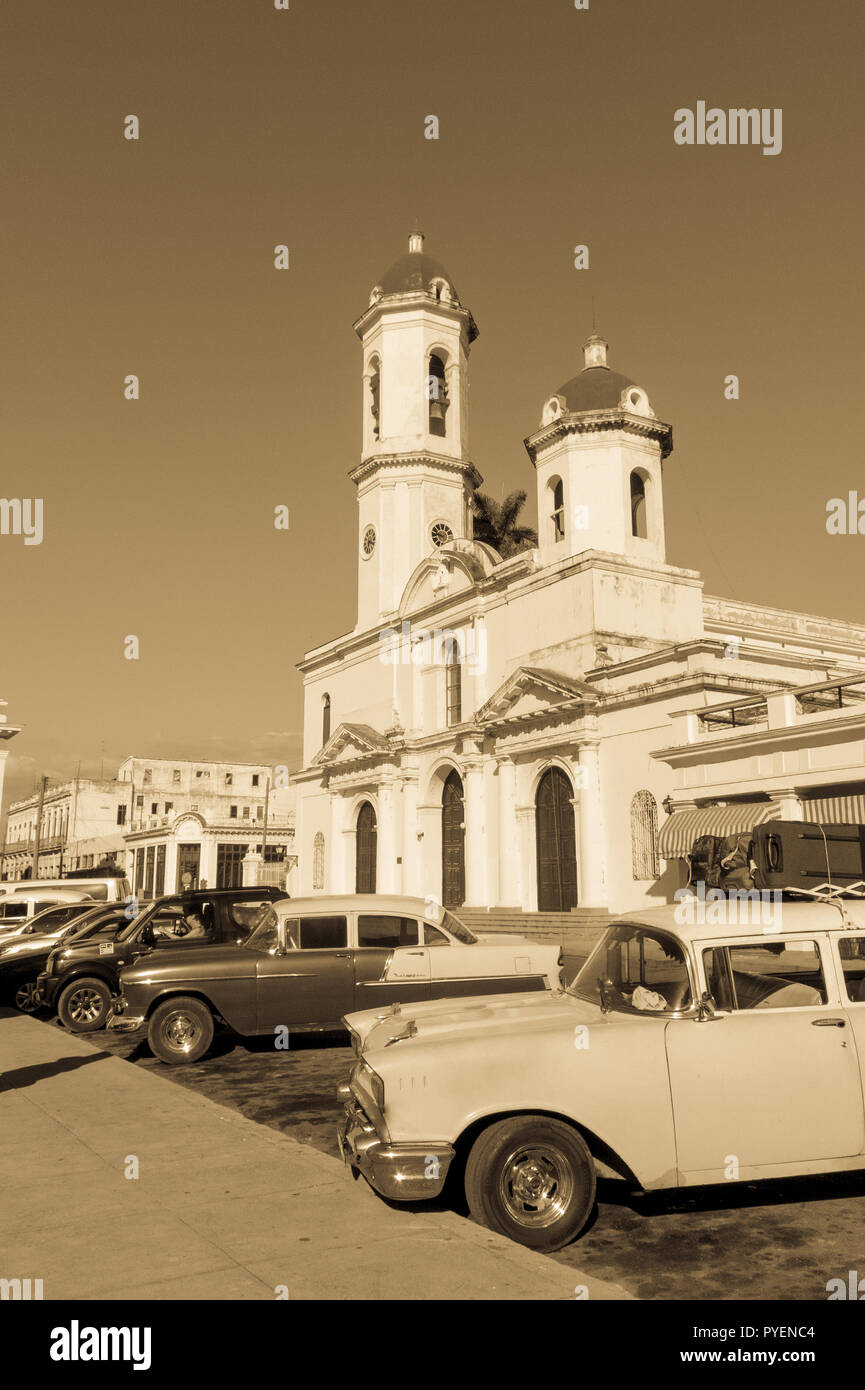 CIENFUEGOS, Kuba - 3. JANUAR 2017: Oldtimer in Jose Marti Park, dem Hauptplatz von Cienfuegos, vor dem Purisima Concepcion Kathedrale. Cie Stockfoto