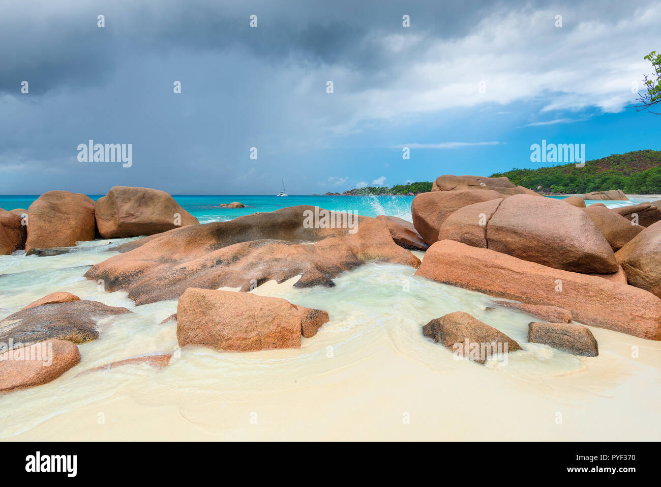 Schöne Steine am Sandstrand und das türkisfarbene Meer in Seychellen Stockfoto