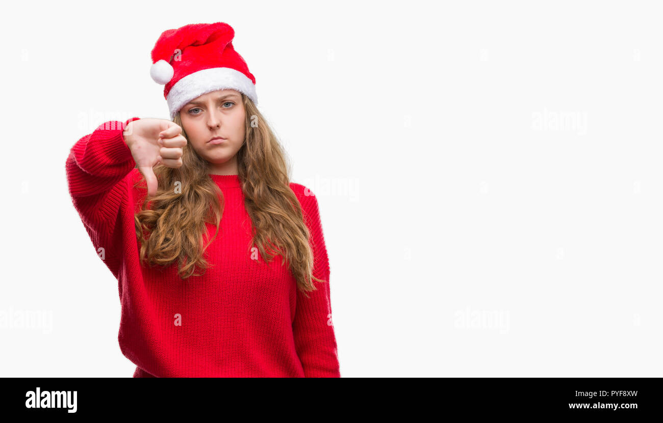 Junge blonde Frau, tragen, Santa Claus hat mit Verärgerten Gesicht, negatives Vorzeichen zeigen Abneigung mit Daumen nach unten, Ablehnung Konzept Stockfoto