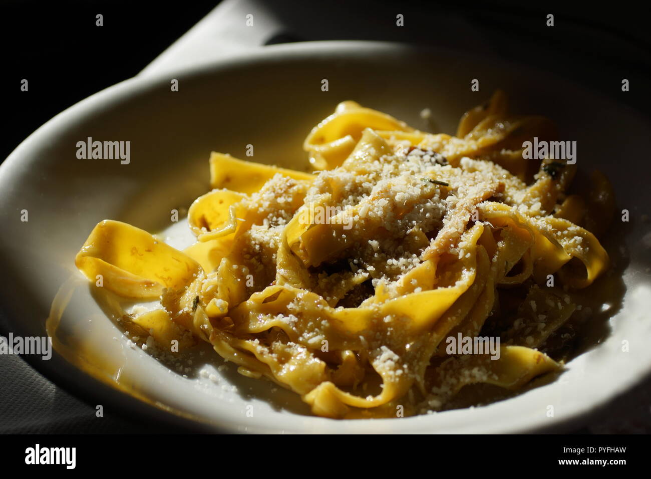 Fettuccine Pasta mit Steinpilzen gekocht. Das fertige Gericht ist mit geriebenem Parmesan bestreut. Stockfoto