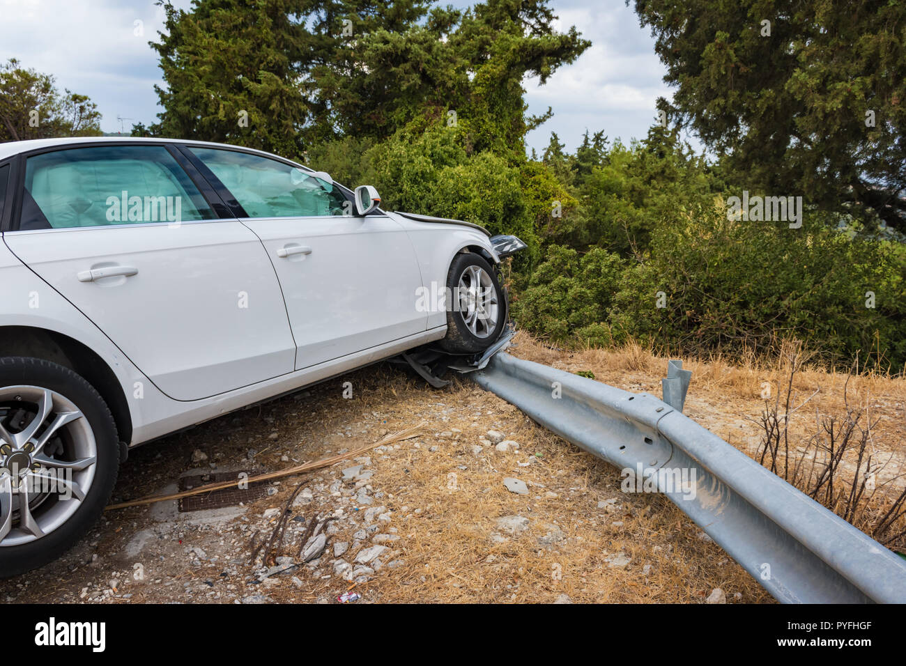 Zerschmetterte Auto mit deflationiert Airbags nach Unfall auf der Straße fertig Barriere abgestuerzt Stockfoto