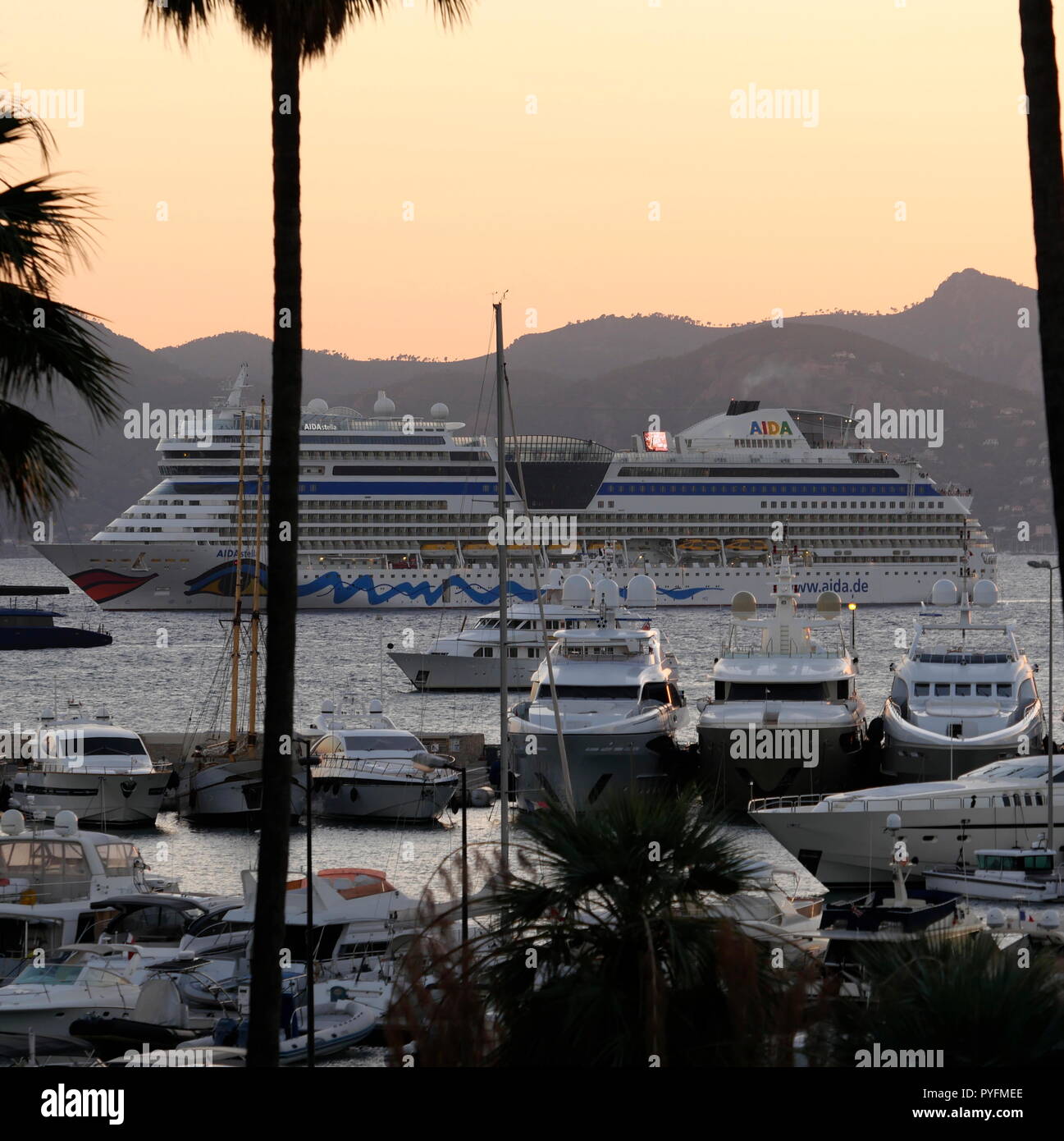 AJAXNETPHOTO. 2018. CANNES, Frankreich. - COTE D'AZUR RESORT - BLICK NACH WESTEN ÜBER DIE BUCHT VON CANNES MIT SUPER Yachten und Kreuzfahrtschiffe vertäut im Hafen PIERRE CANTO MARINA im Vordergrund, das Kreuzfahrtschiff AIDA STELLA in der Bucht vor Anker liegt. Foto: Jonathan Eastland/AJAX REF: GX8 182509 666 Stockfoto