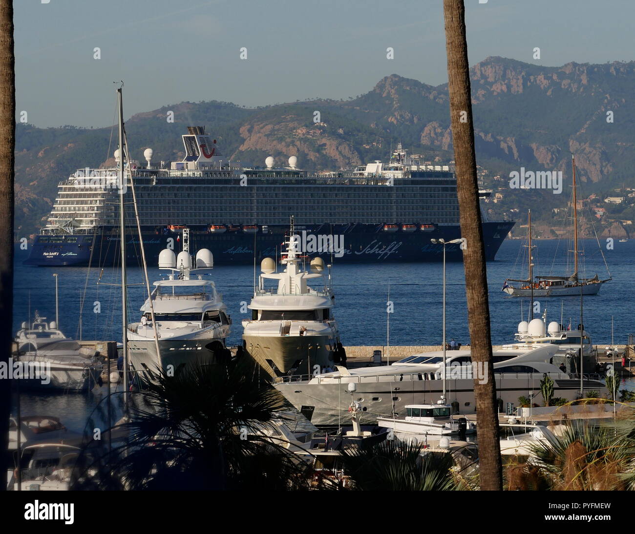 AJAXNETPHOTO. 2018. CANNES, Frankreich. - COTE D'AZUR RESORT - BLICK NACH WESTEN ÜBER DIE BUCHT VON CANNES MIT SUPER Yachten und Kreuzfahrtschiffe vertäut im Hafen PIERRE CANTO MARINA im Vordergrund, das KREUZFAHRTSCHIFF MEIN SCHIFF 3 in der Bucht vor Anker liegt. Foto: Jonathan Eastland/AJAX REF: GX8 182509 681 Stockfoto