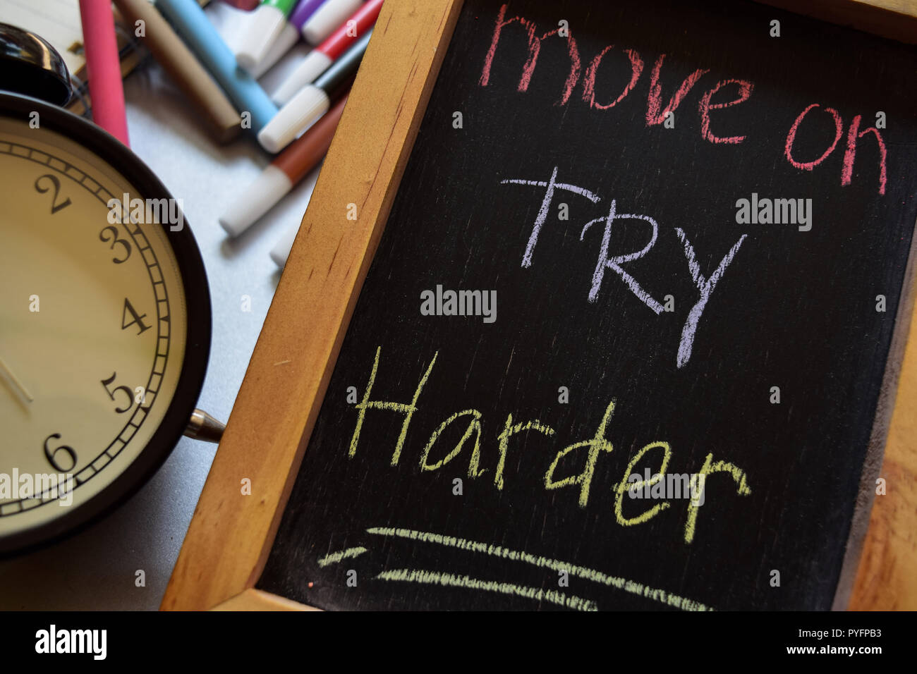 Auf try harder auf Phrase bunte handgeschrieben auf Schwarzes Brett, Wecker mit Motivation und Bildung Konzepte bewegen Stockfoto
