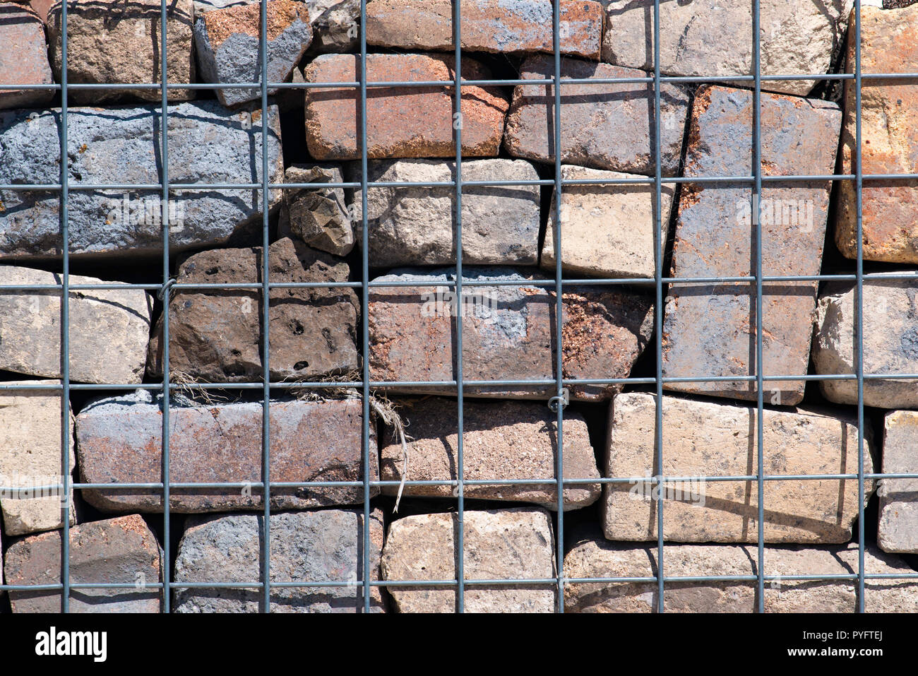 Eine Stützmauer mit vielfarbigen recycelte Ziegel von Steel mesh in Australien unterstützt. Stockfoto