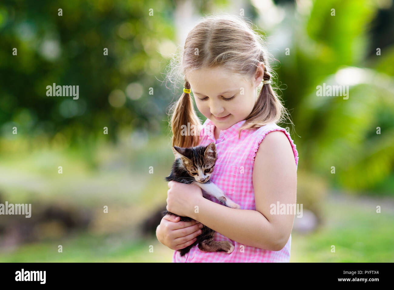 Kind Holding Baby Katze. Kinder und Haustiere. Kleines Mädchen umarmt niedlichen kleinen Kätzchen im Sommer Garten. Haustier in der Familie mit Kindern. Kinder mit hom Stockfoto