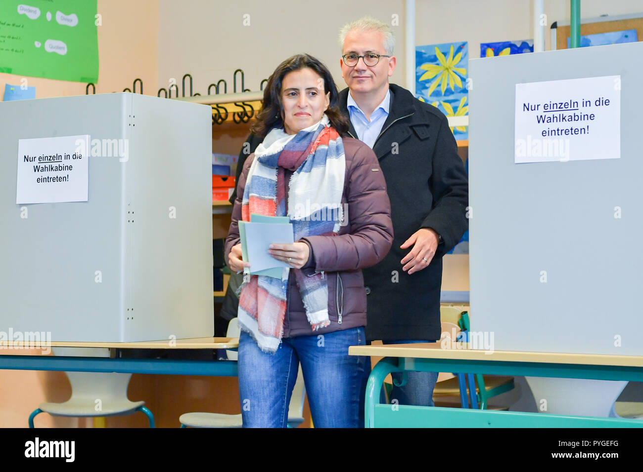 Offenbach, Deutschland. 28 Okt, 2018. Tarek Al-Wazir, dem hessischen Wirtschafts- und Verkehrsminister und Spitzenkandidat von Bündnis 90/Die Grünen, und seine Frau Bushra Barakat verlassen die wahlkabine an der Ernst-Reuter-Schule. Foto: Uwe Anspach/dpa/Alamy leben Nachrichten Stockfoto