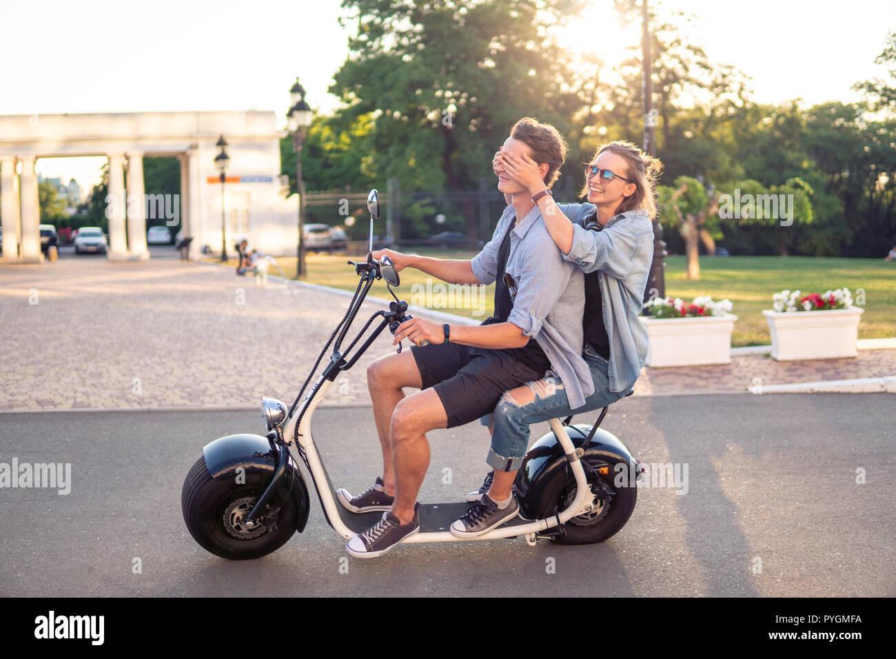 Reizende junge glückliches Paar fahren Elektrofahrrad Stockfoto