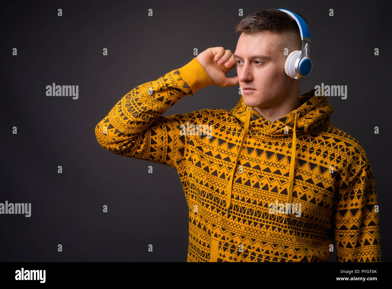 Porträt der jungen gutaussehenden Mann Musik hören mit Kopfhörern Stockfoto