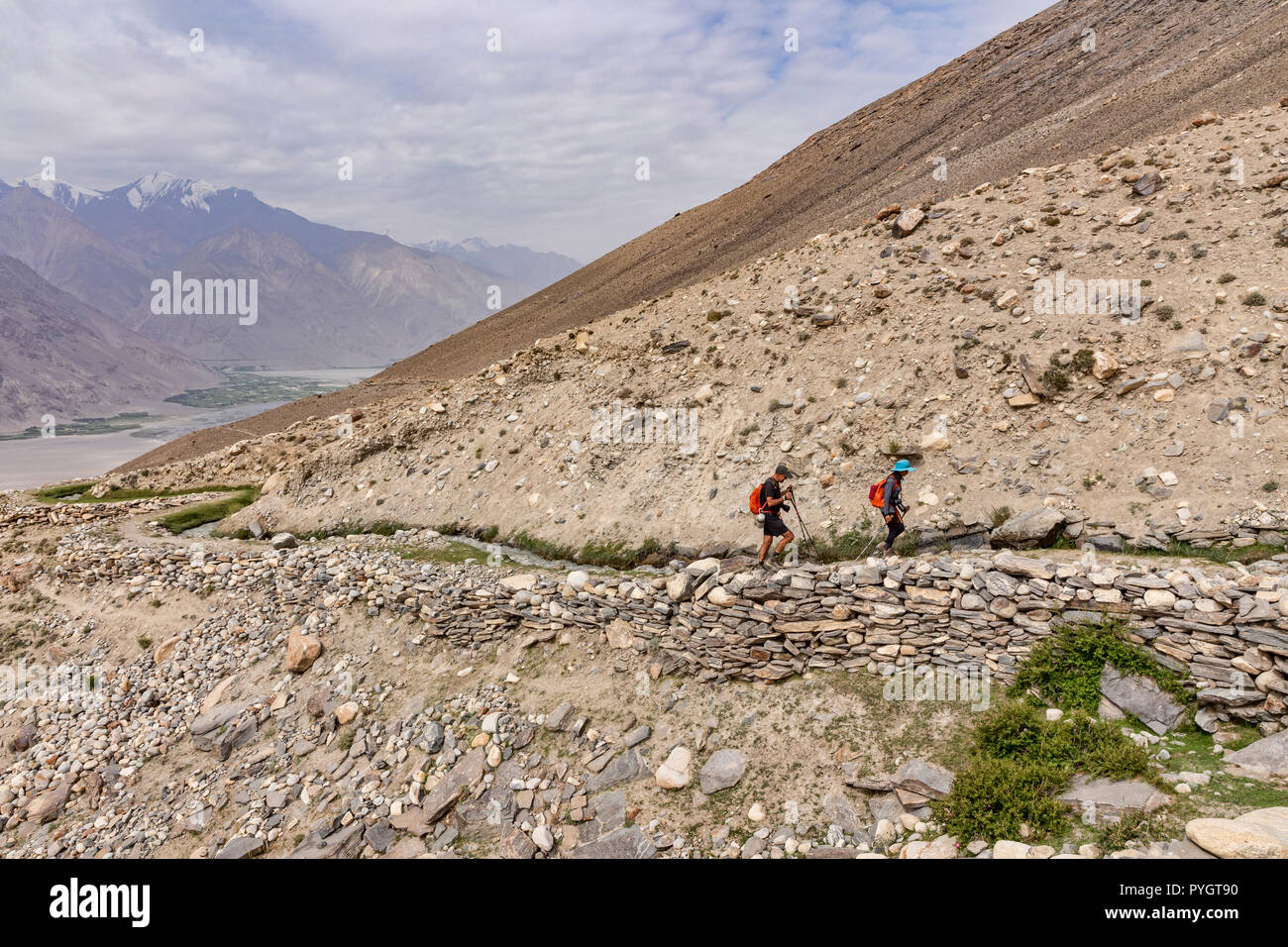 Wanderer Wandern der wunderschöne Engels Peak Hill trek neben einem traditionellen Pamiri Deich, oder Wasser Kanal, Langar, tadschikischen Wakhan, Pamir, Taj Stockfoto
