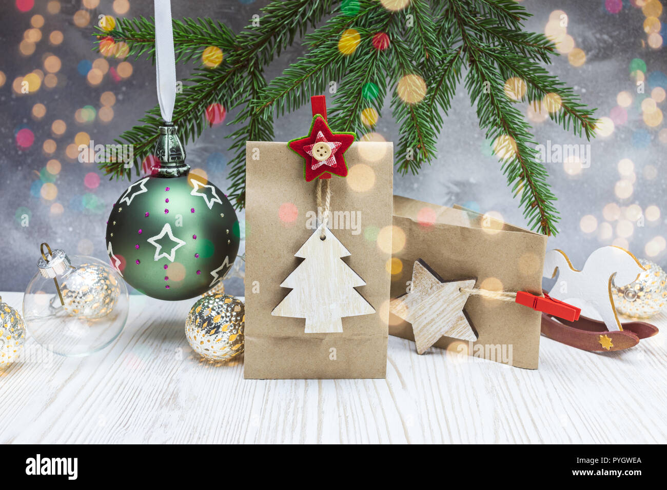 Weihnachten festliche Hintergrund mit Fir Tree Branch, Papier Geschenk Taschen, Bälle und Holzdekorationen Stockfoto