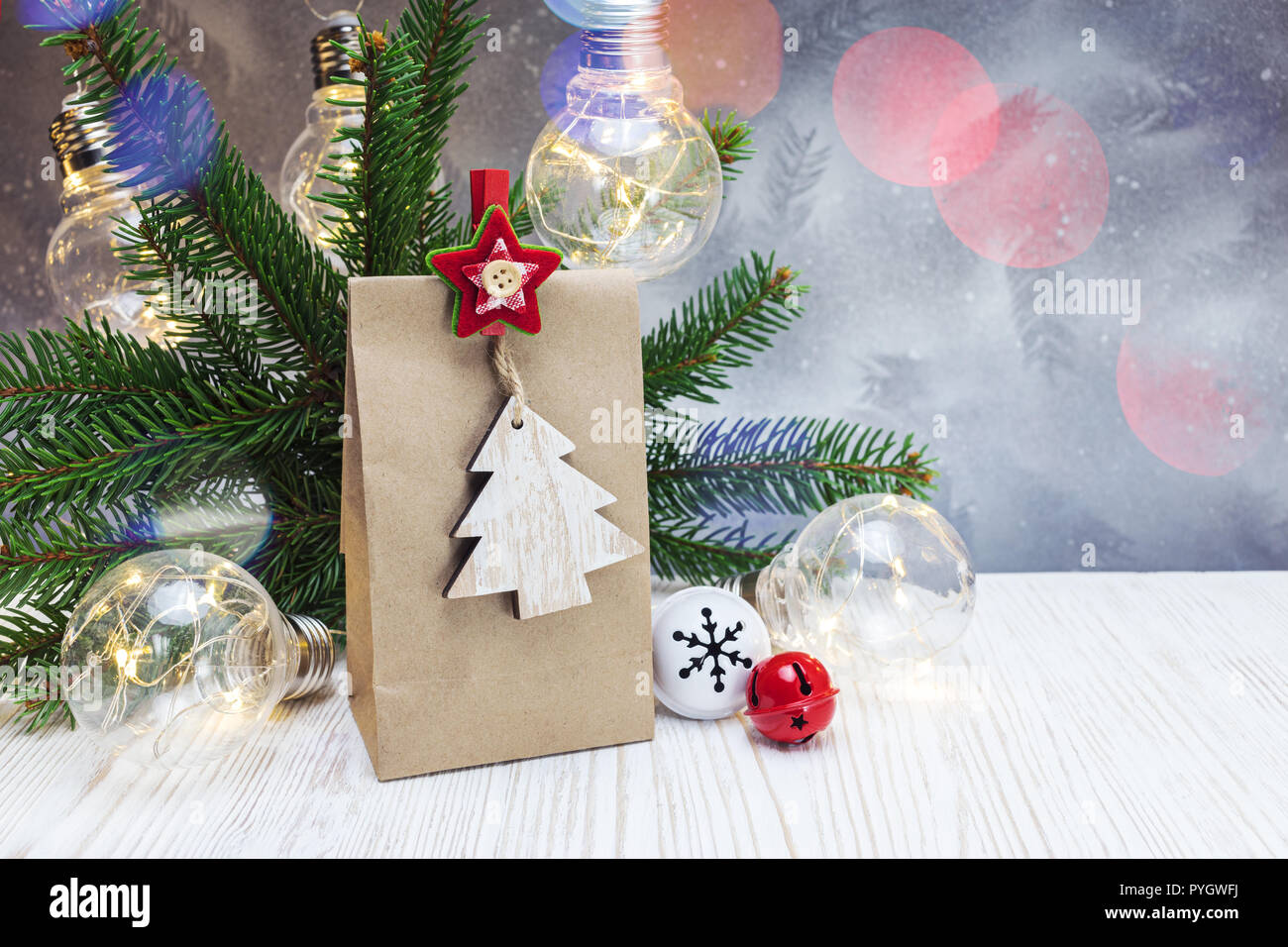 Silber festliche Weihnachten Hintergrund mit retro Licht Lampen, grüne Tanne Baum, handgemachtem Papier-vorhanden-Tasche mit Holz- dekorative Stift Stockfoto