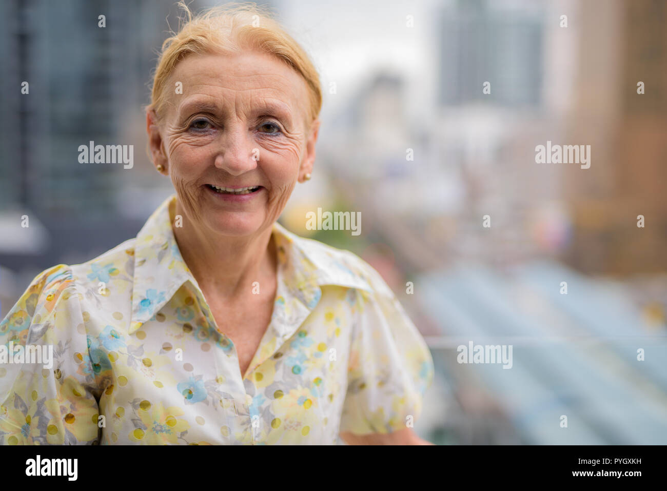 Gerne schöne ältere Frau lächelnd im Freien in der Stadt Stockfoto
